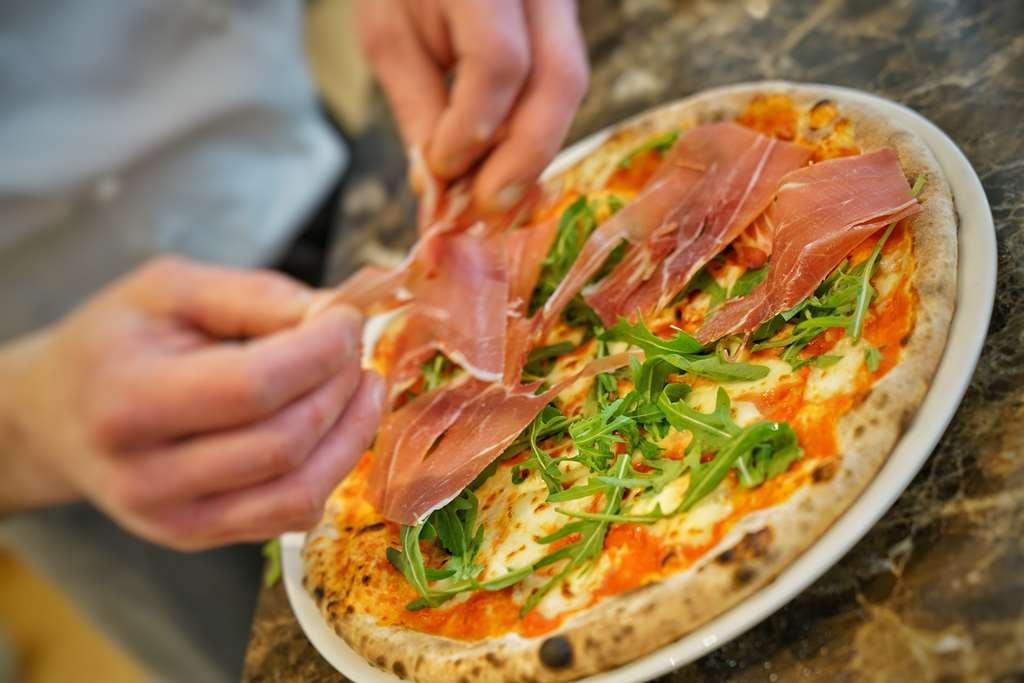 Vila Vita Rosenpark Marburg Bagian luar foto Pizza being topped with prosciutto